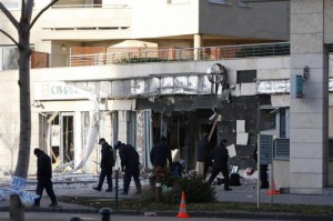 Police inspect the front of a destroyed facade of CIB bank building is seen in Budapest
